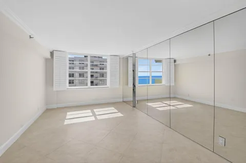 a view of a electric appliances in kitchen and empty room with wooden floor