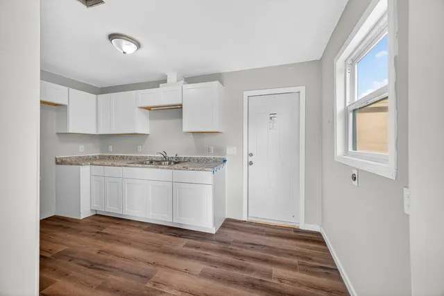a kitchen with granite countertop white cabinets and white appliances