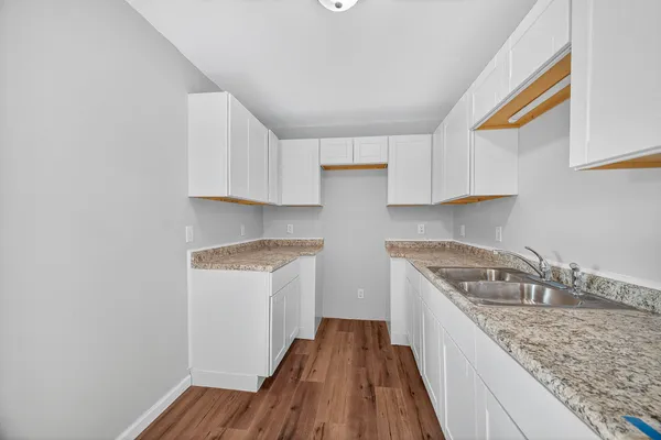 a kitchen with granite countertop a sink a stove and cabinets
