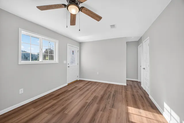 a view of empty room with wooden floor