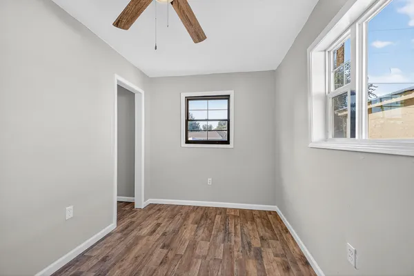 an empty room with a window and wooden floor