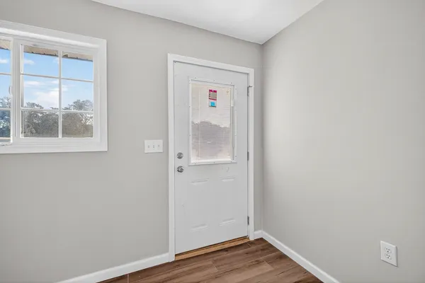 an empty room with wooden floor and a window