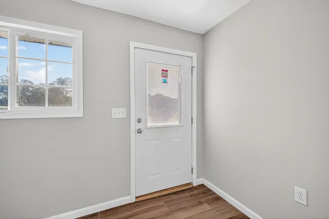 an empty room with wooden floor and a window