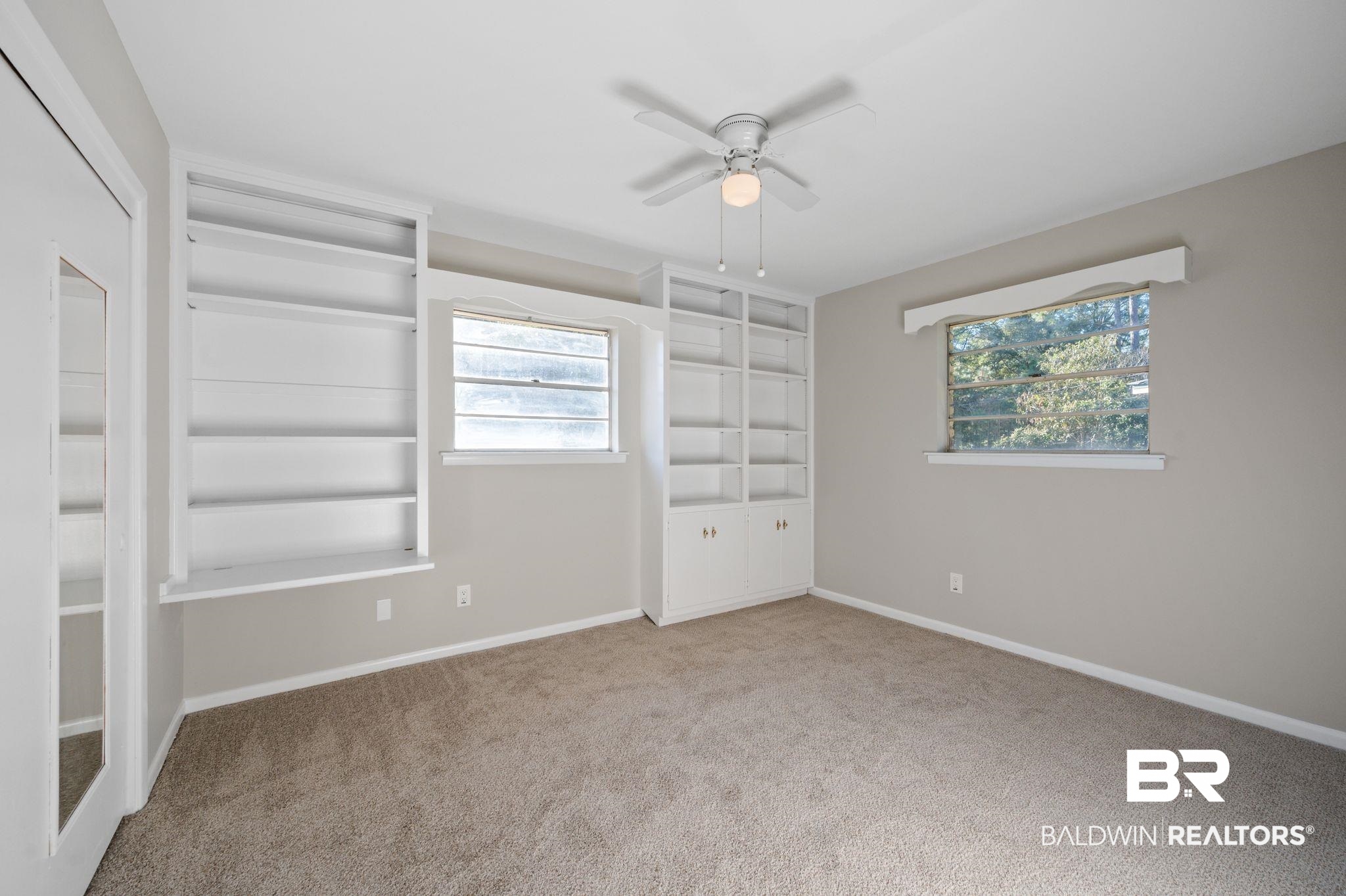 909 Caroline Avenue Daphne, AL 36526 - Photo 29 of 46 Unfurnished bedroom featuring multiple windows, carpet flooring, and ceiling fan