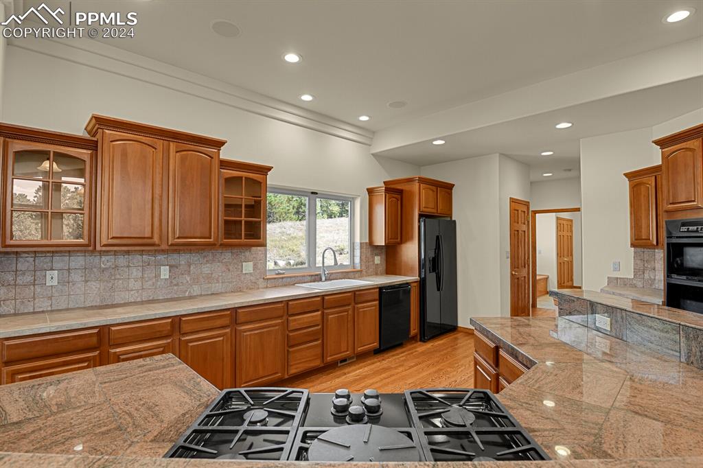 810 Dolan Drive Monument, CO 80132 - Photo 12 of 50 a kitchen with stainless steel appliances granite countertop a sink stove and refrigerator