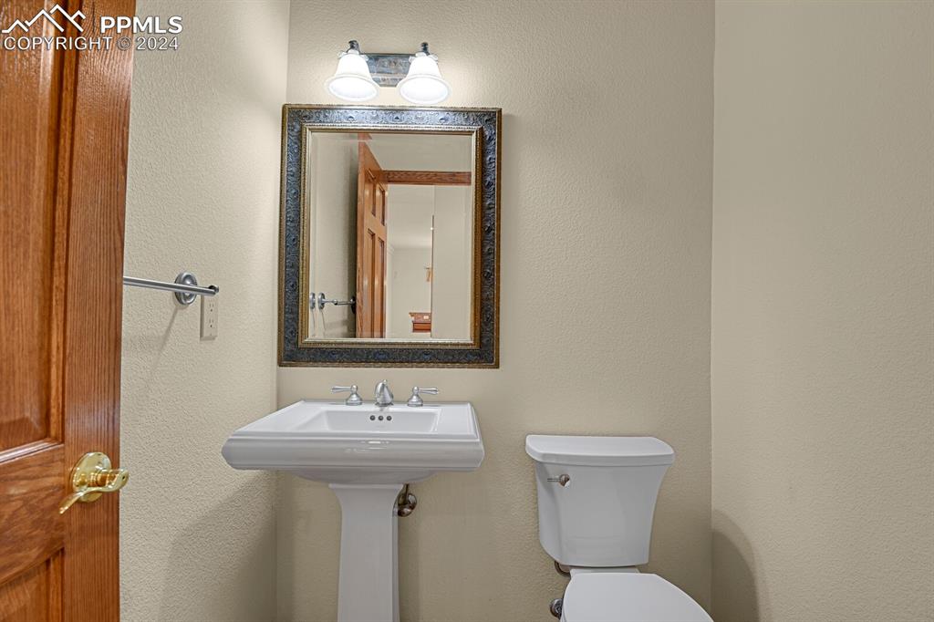 810 Dolan Drive Monument, CO 80132 - Photo 16 of 50 a bathroom with a toilet sink and mirror