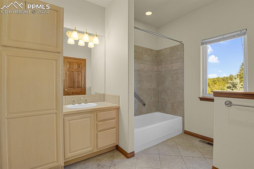 810 Dolan Drive Monument, CO 80132 - Photo 47 of 50 a bathroom with a tub sink and mirror