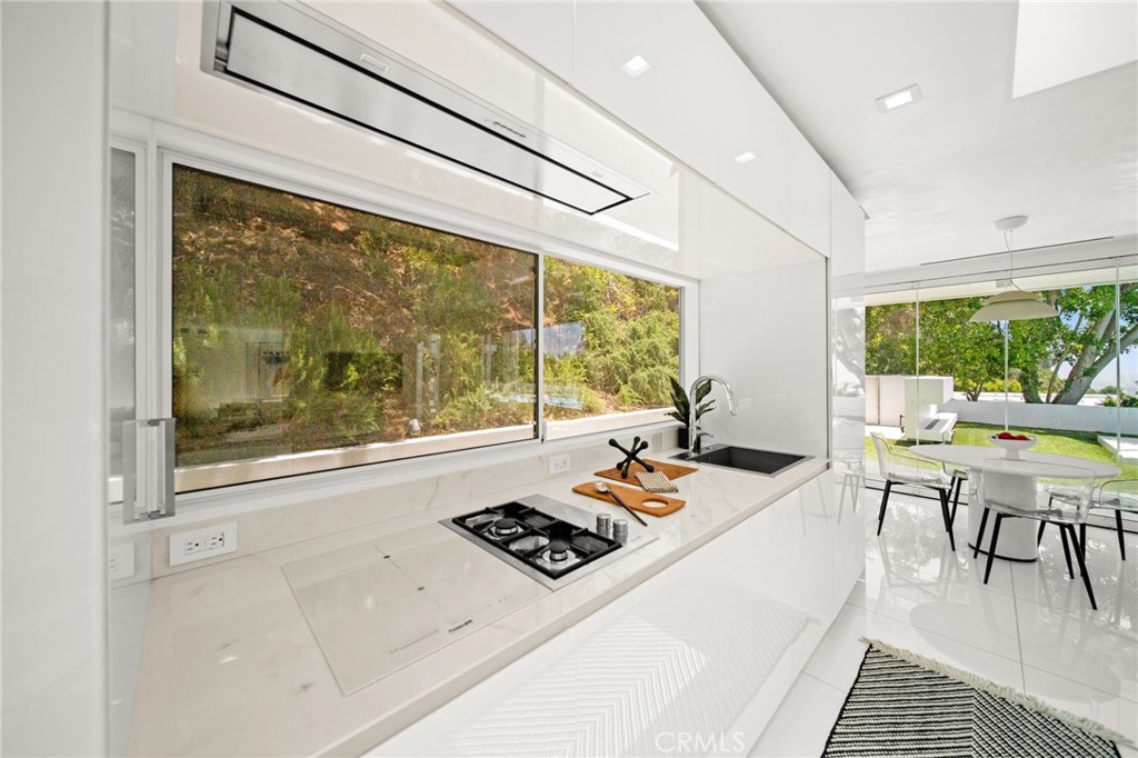 1046 North Hillcrest Road Beverly Hills, CA 90210 - Photo 23 of 74 a living room with hard wood floors and a table