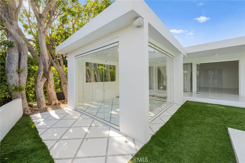 1046 North Hillcrest Road Beverly Hills, CA 90210 - Photo 65 of 74 a front view of a house with a yard