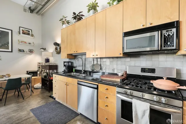 a kitchen with stainless steel appliances granite countertop a sink a stove and refrigerator