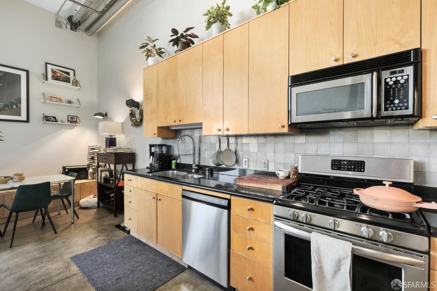 60 Rausch Street, Unit 303 San Francisco, CA 94103 - Photo 6 of 39 a kitchen with stainless steel appliances granite countertop a stove a sink and a microwave