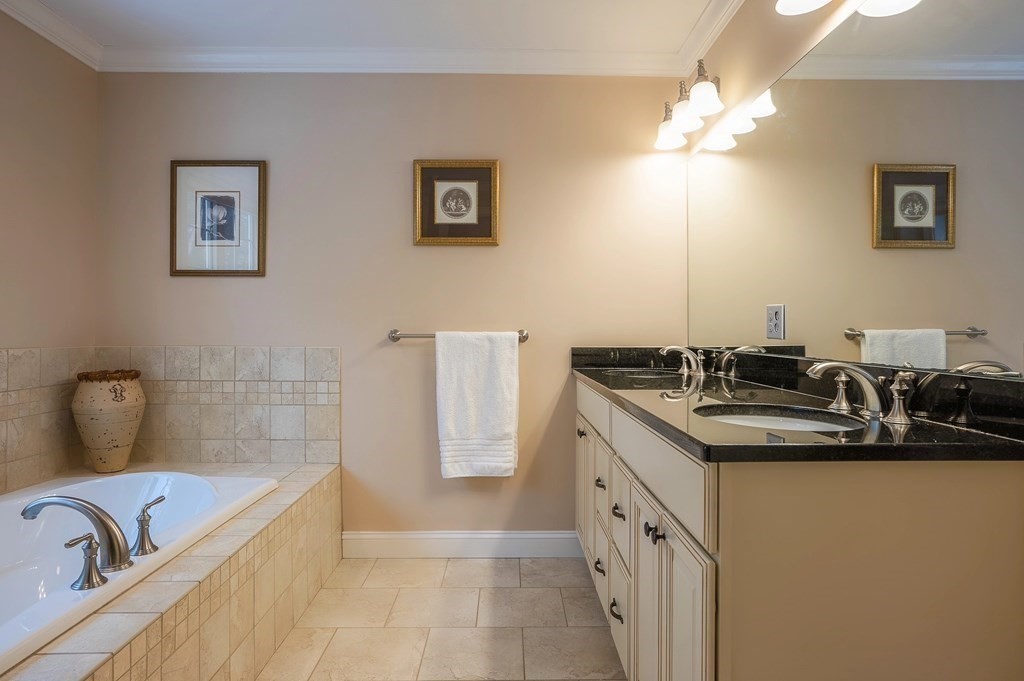 157 Cedar Street Lexington, MA 02421 - Photo 29 of 41 a bathroom with a double vanity sink a mirror and a bathtub