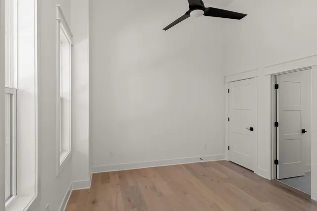 an empty room with windows and closet