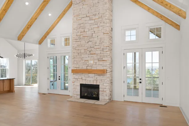 a view of a livingroom with wooden floor a fireplace and windows