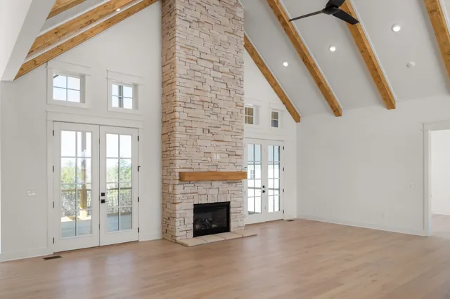 a view of a livingroom with wooden floor a fireplace and window