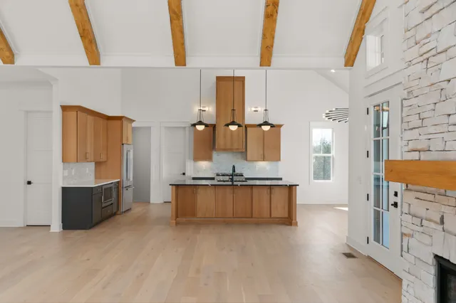 a kitchen with stainless steel appliances granite countertop a sink a stove and a wooden floor