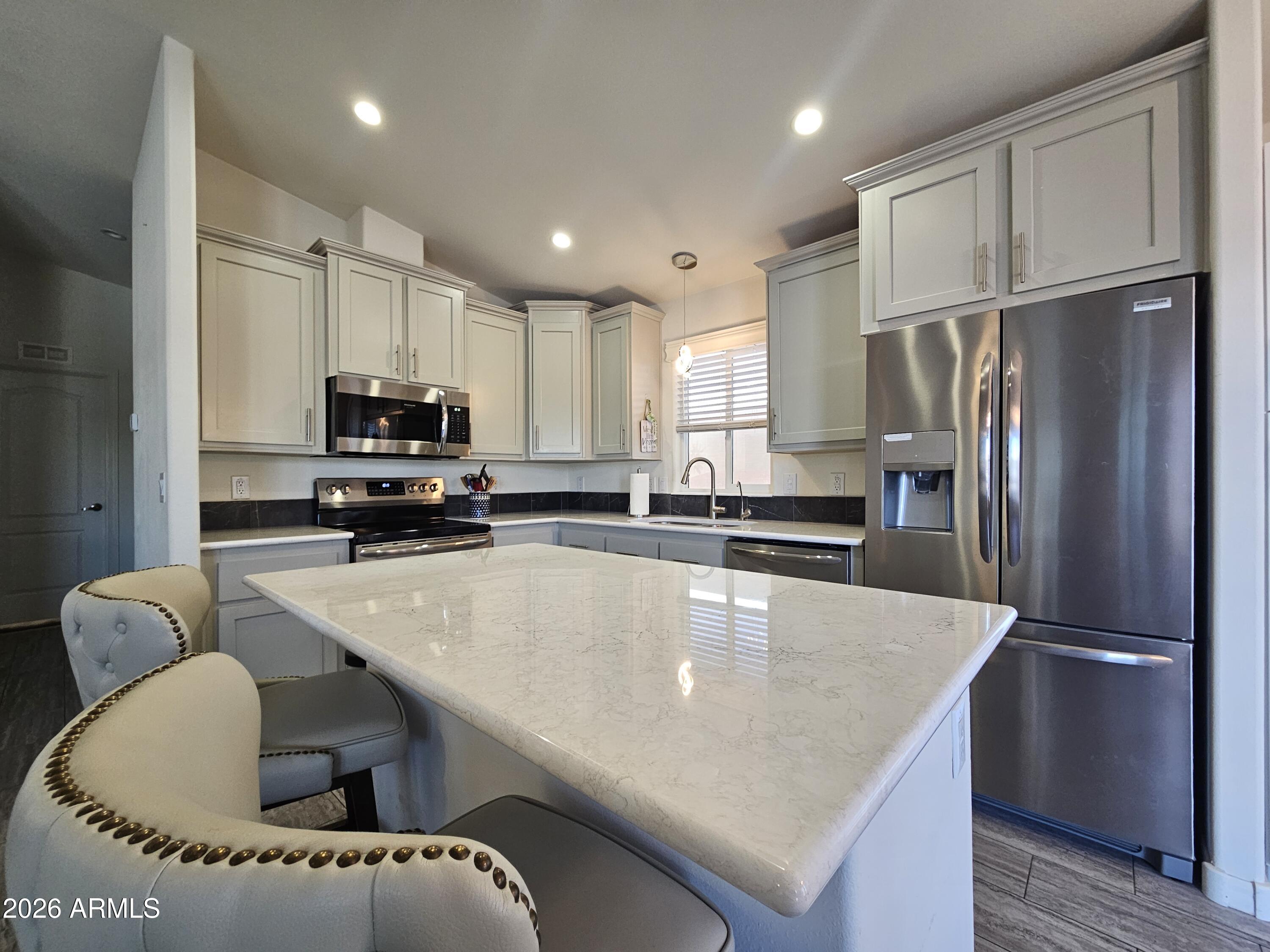 650 North Hawes Road, Unit 3223 Mesa, AZ 85207 - Photo 13 of 39 a kitchen with stainless steel appliances granite countertop a refrigerator a stove a sink dishwasher and a refrigerator with wooden floor