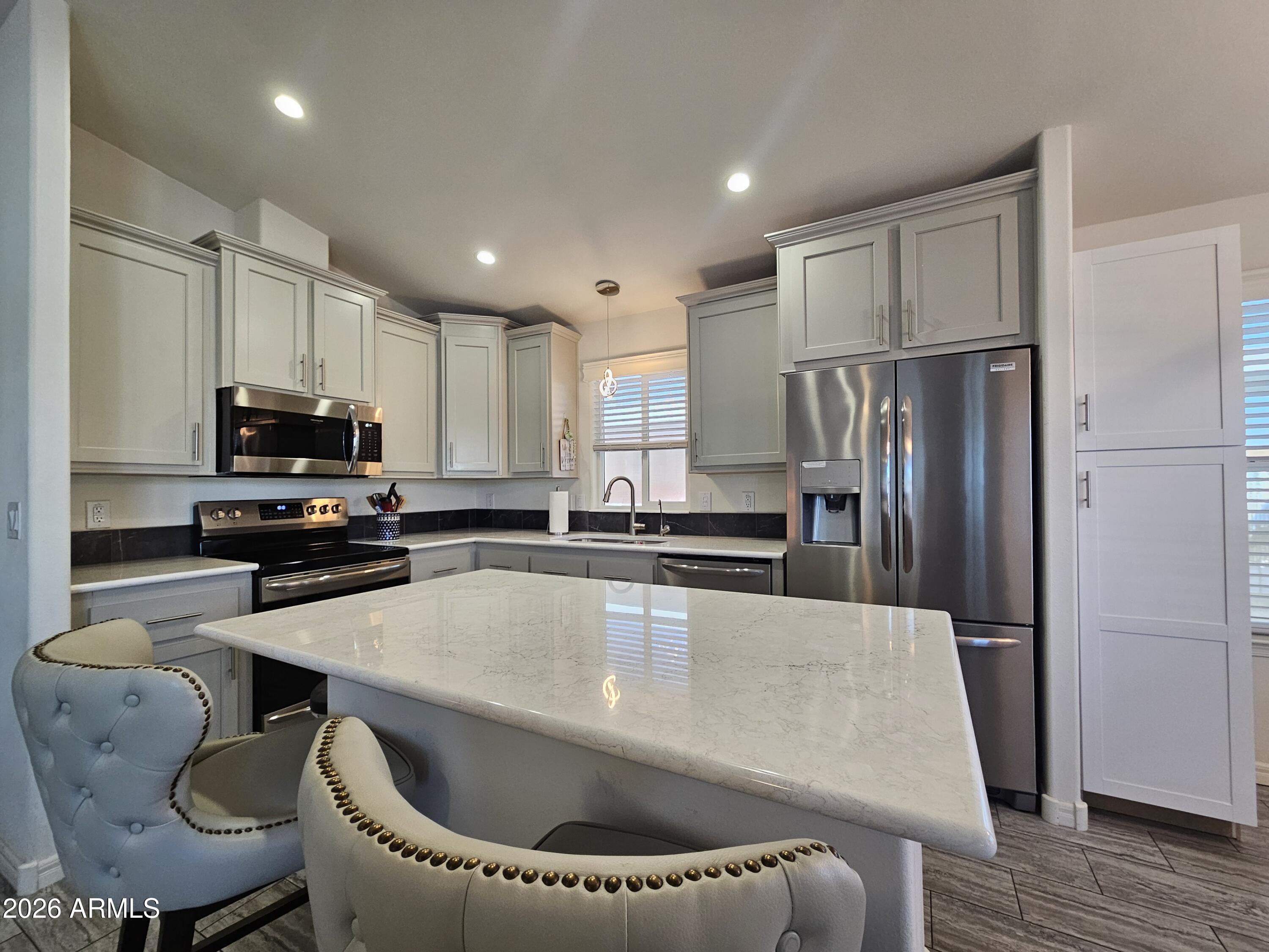 650 North Hawes Road, Unit 3223 Mesa, AZ 85207 - Photo 15 of 39 a kitchen with kitchen island a appliances and wooden cabinets