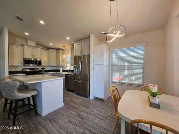 a kitchen with refrigerator a sink and chairs
