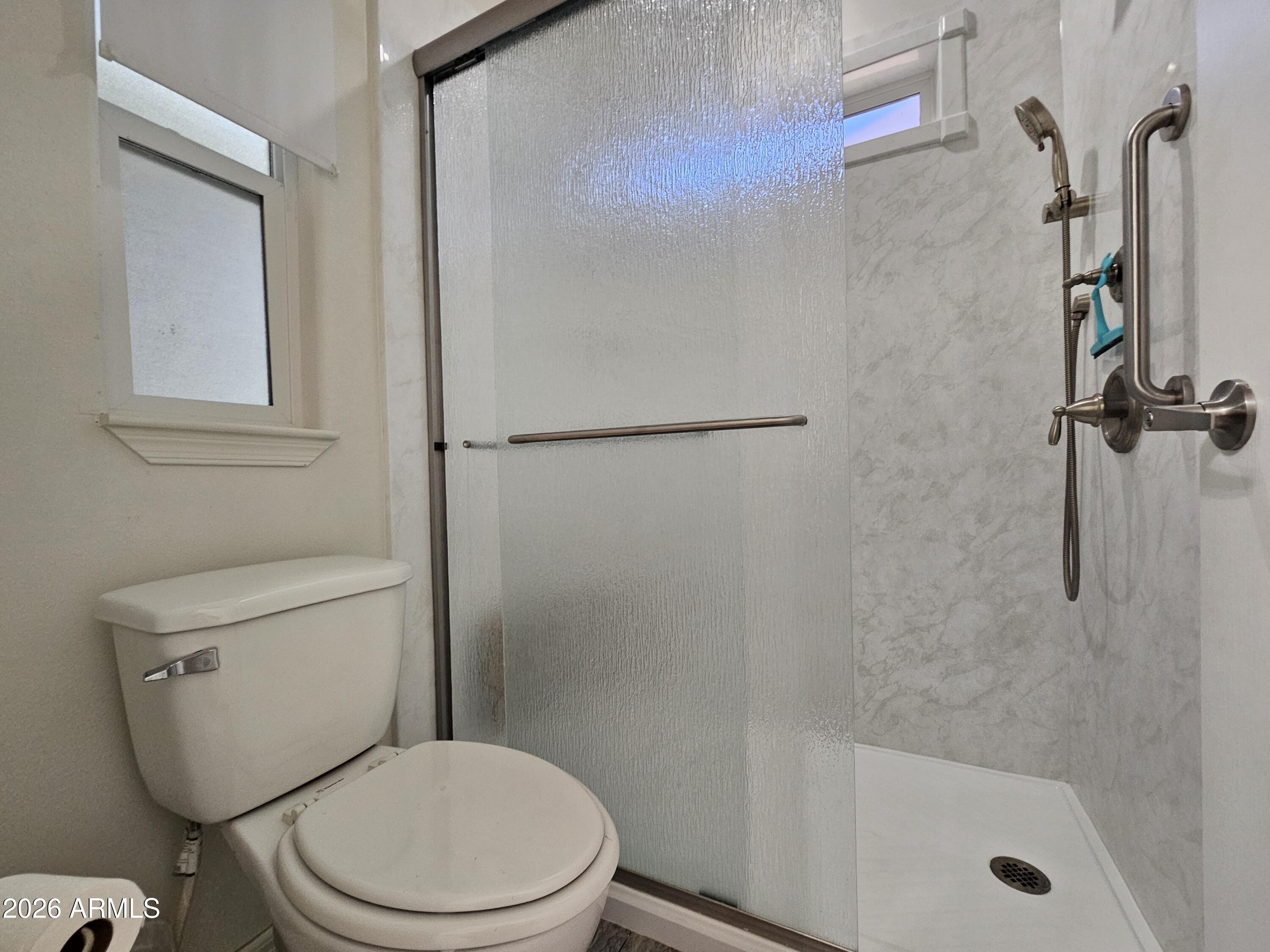 650 North Hawes Road, Unit 3223 Mesa, AZ 85207 - Photo 27 of 39 a white toilet sitting next to a bath tub shower