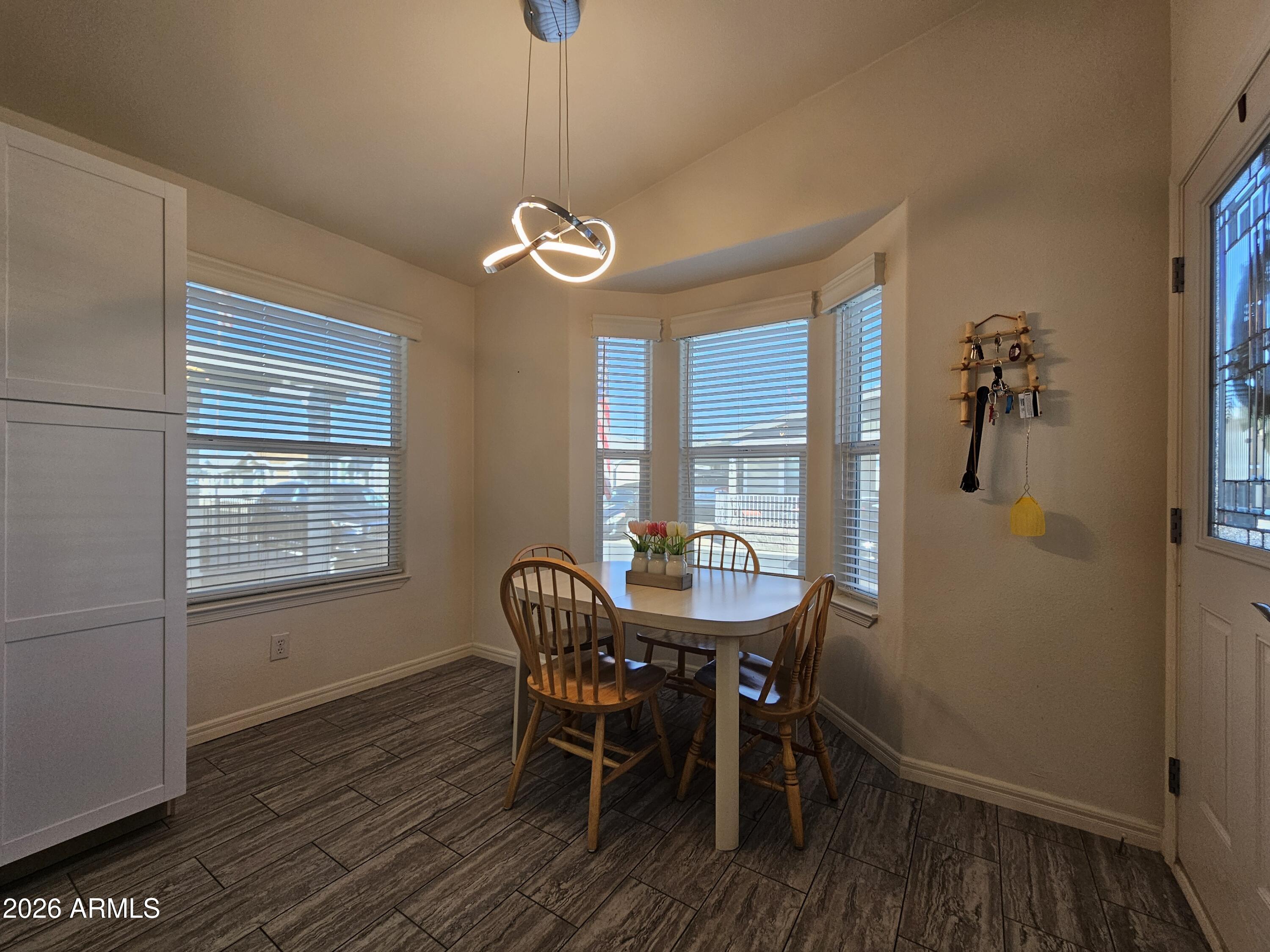 650 North Hawes Road, Unit 3223 Mesa, AZ 85207 - Photo 3 of 39 a view of a dining room with furniture window and wooden floor