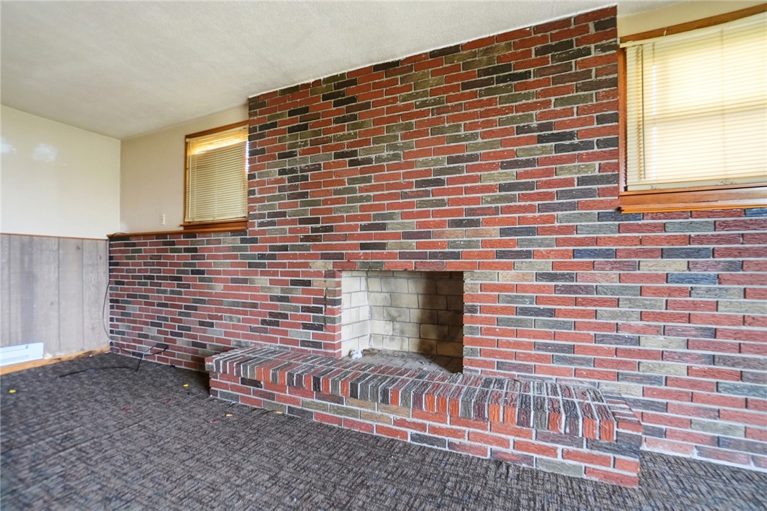 9750 Middlepoint Road Middle Point, OH 45863 - Photo 27 of 43 This living area features a robust brick fireplace, offering a foundational element for a cozy atmosphere.