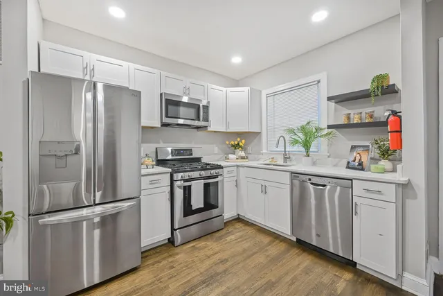 a kitchen with stainless steel appliances a refrigerator sink and microwave