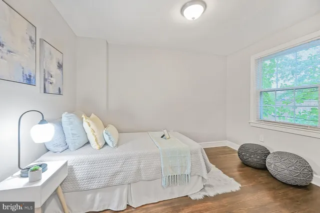 a bedroom with a bed and closet with wooden floor