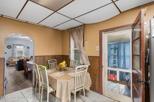 a dining room with furniture and a floor to ceiling window