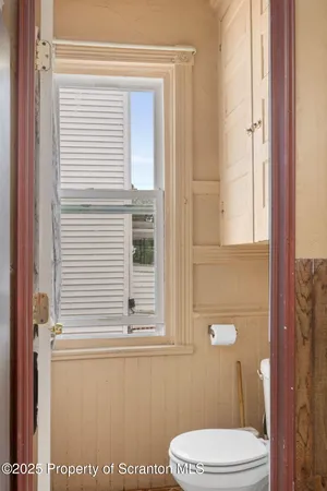 a bathroom with a toilet a sink and a window