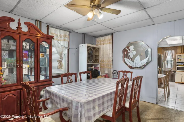 a dining room with furniture a rug and a mirror