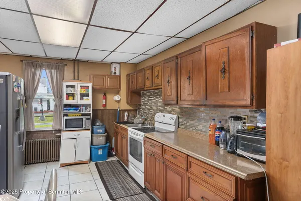 a kitchen with stainless steel appliances granite countertop a refrigerator and wooden cabinets