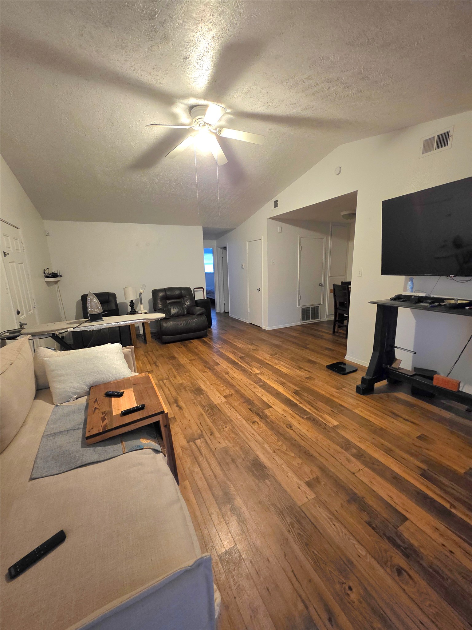 15208 Spring Hill Lane, Unit A Pflugerville, TX 78660 - Photo 6 of 16 Vaulted ceiling with a central ceiling fan, wood-finish flooring, and white painted walls