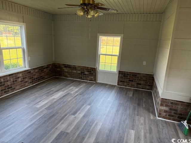 2851 Highway 984 Galivants Ferry, SC 29544 - Photo 16 of 23 Unfurnished room featuring brick wall, ceiling fan, and dark wood-type flooring