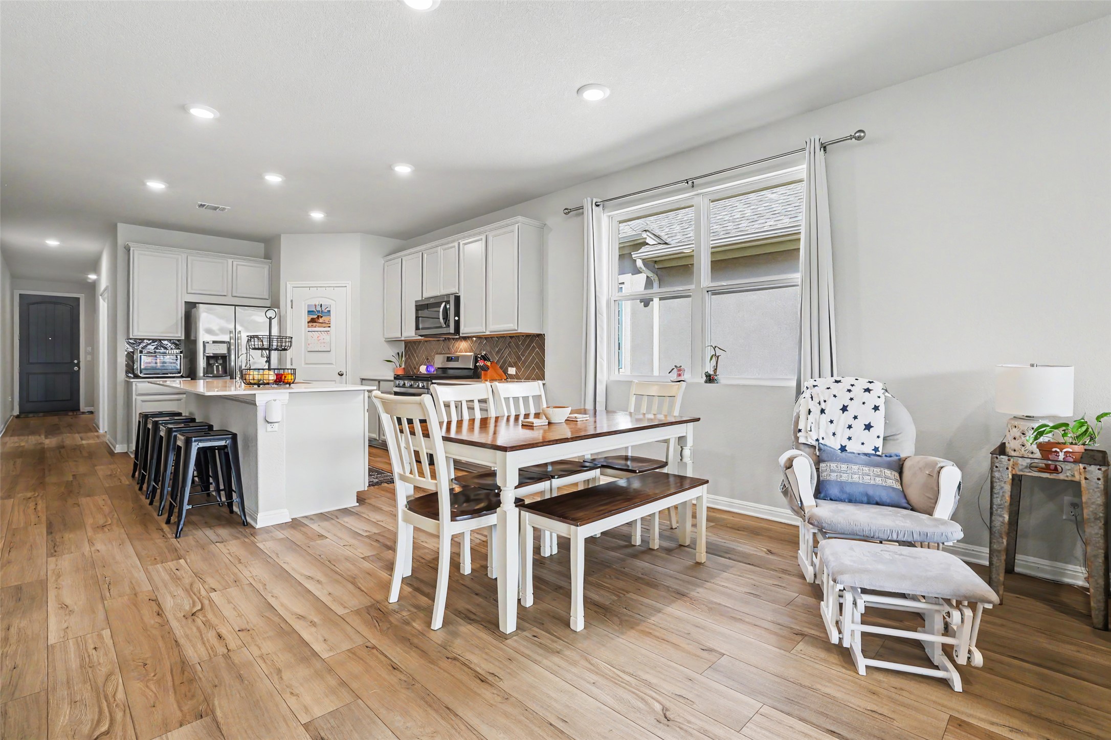 112 Rocking R Court Georgetown, TX 78633 - Photo 11 of 40 An inviting open-concept layout unites the kitchen and dining areas, boasting warm wood flooring throughout.