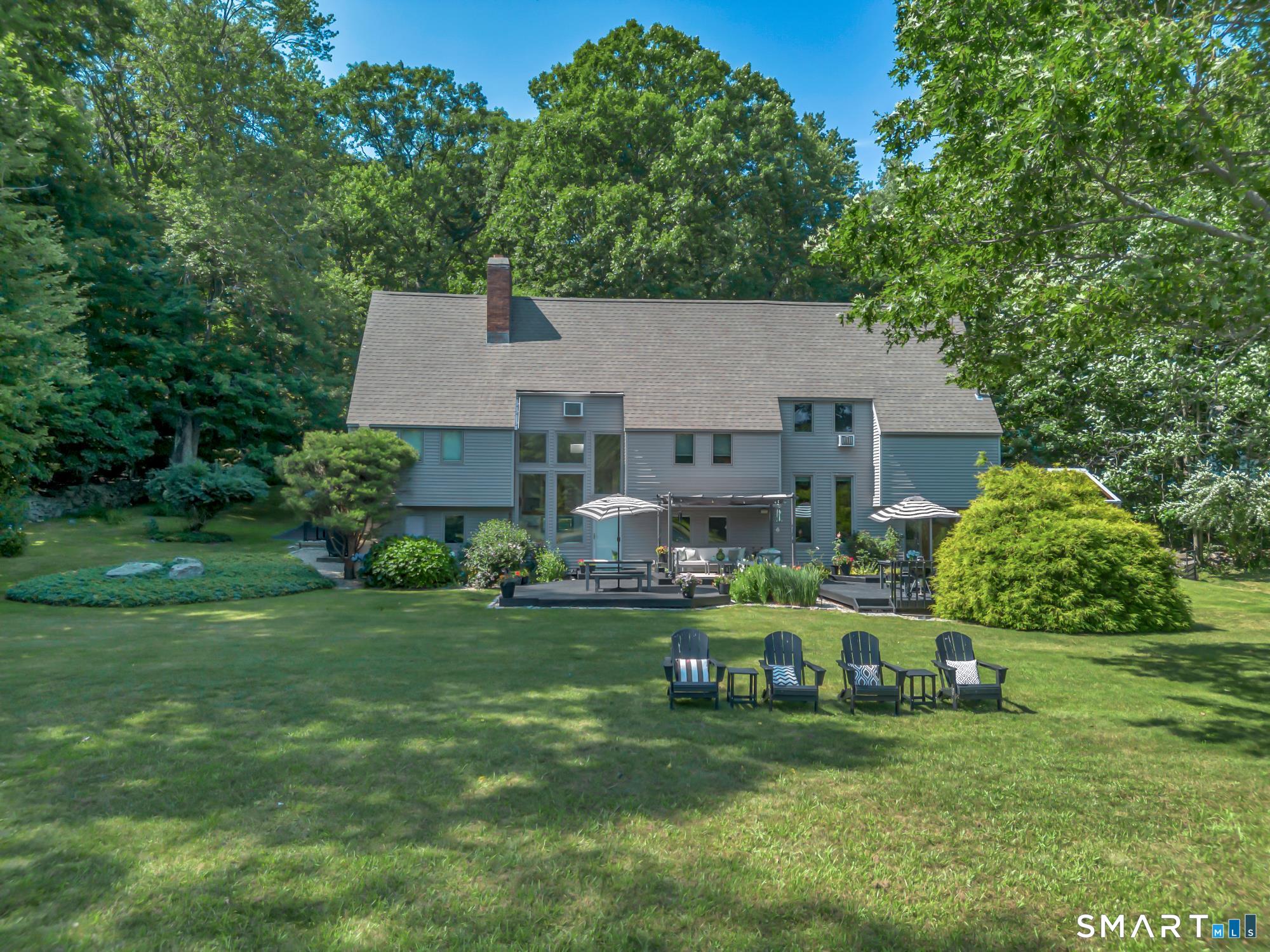 106 Hunt Road Columbia, CT 06237 - Photo 4 of 40 a front view of a house with a garden and trees