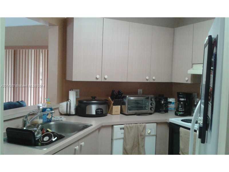 9702 Southwest 138th Avenue, Unit 9702 Miami, FL 33186 - Photo 2 of 15 a kitchen with a sink cabinets and window
