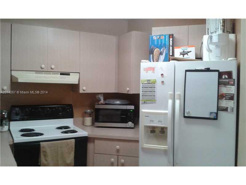 9702 Southwest 138th Avenue, Unit 9702 Miami, FL 33186 - Photo 3 of 15 a kitchen with stainless steel appliances kitchen island a stove a refrigerator and a sink