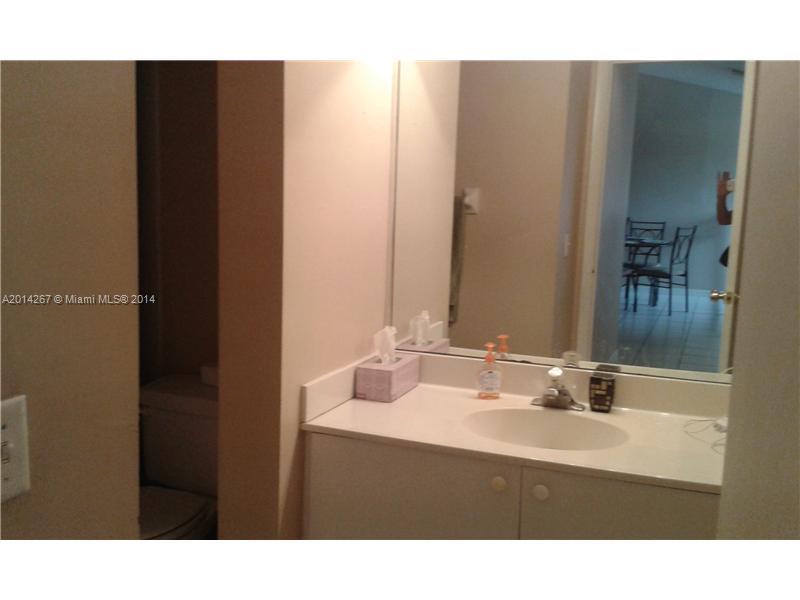 9702 Southwest 138th Avenue, Unit 9702 Miami, FL 33186 - Photo 6 of 15 a bathroom with a sink and a mirror