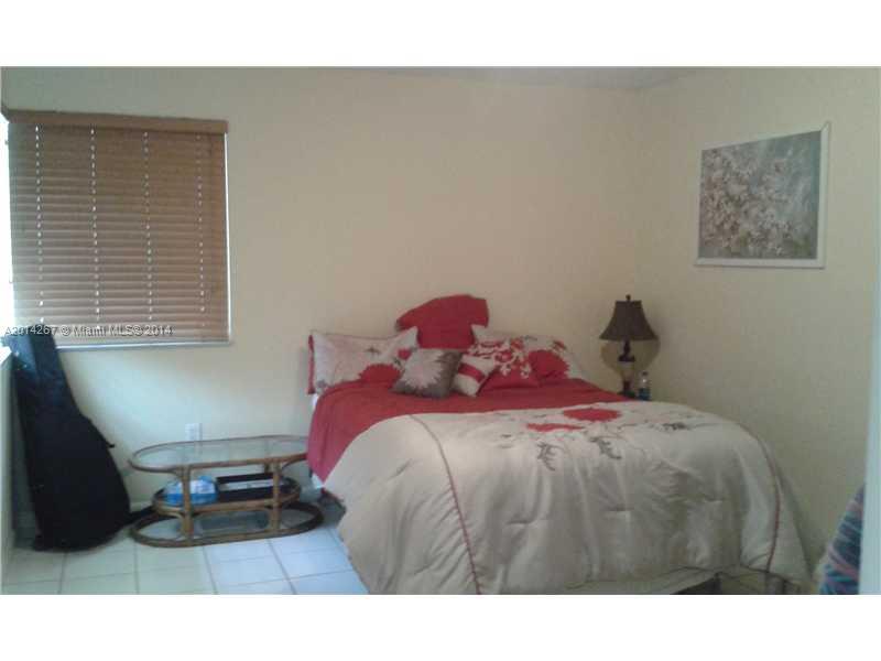 9702 Southwest 138th Avenue, Unit 9702 Miami, FL 33186 - Photo 8 of 15 a bedroom with a bed window and a table