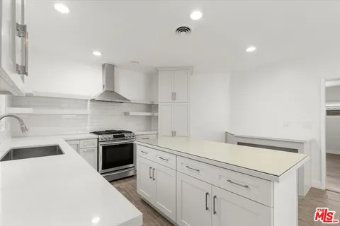 a kitchen with white cabinets and appliances