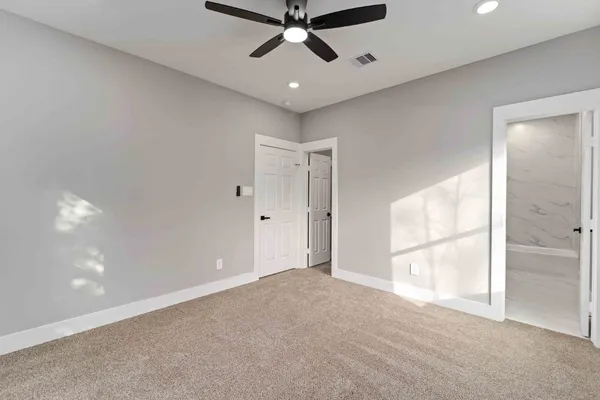 en empty room with windows and ceiling fan