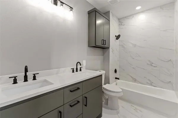 a bathroom with a sink a toilet and shower