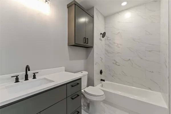 a bathroom with a sink a toilet and shower