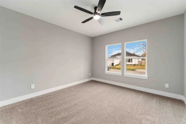 an empty room with a window and a fan