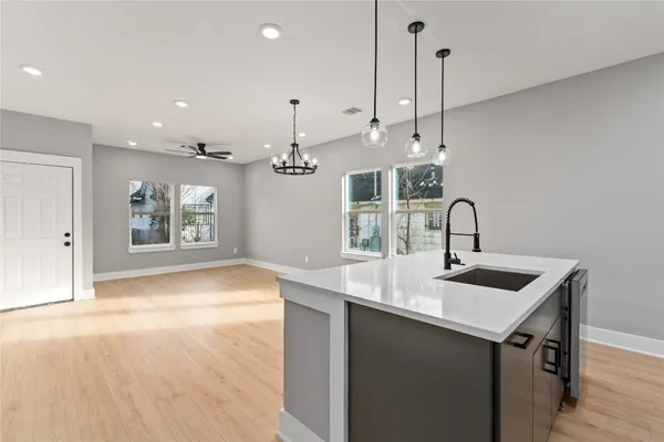 a kitchen with kitchen island a sink appliances and a counter top space