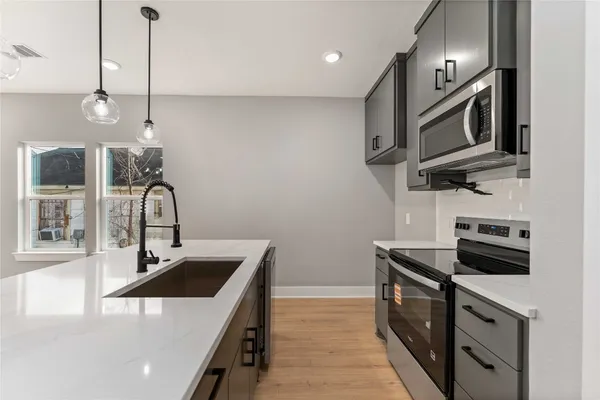a kitchen that has a sink and a stove in it