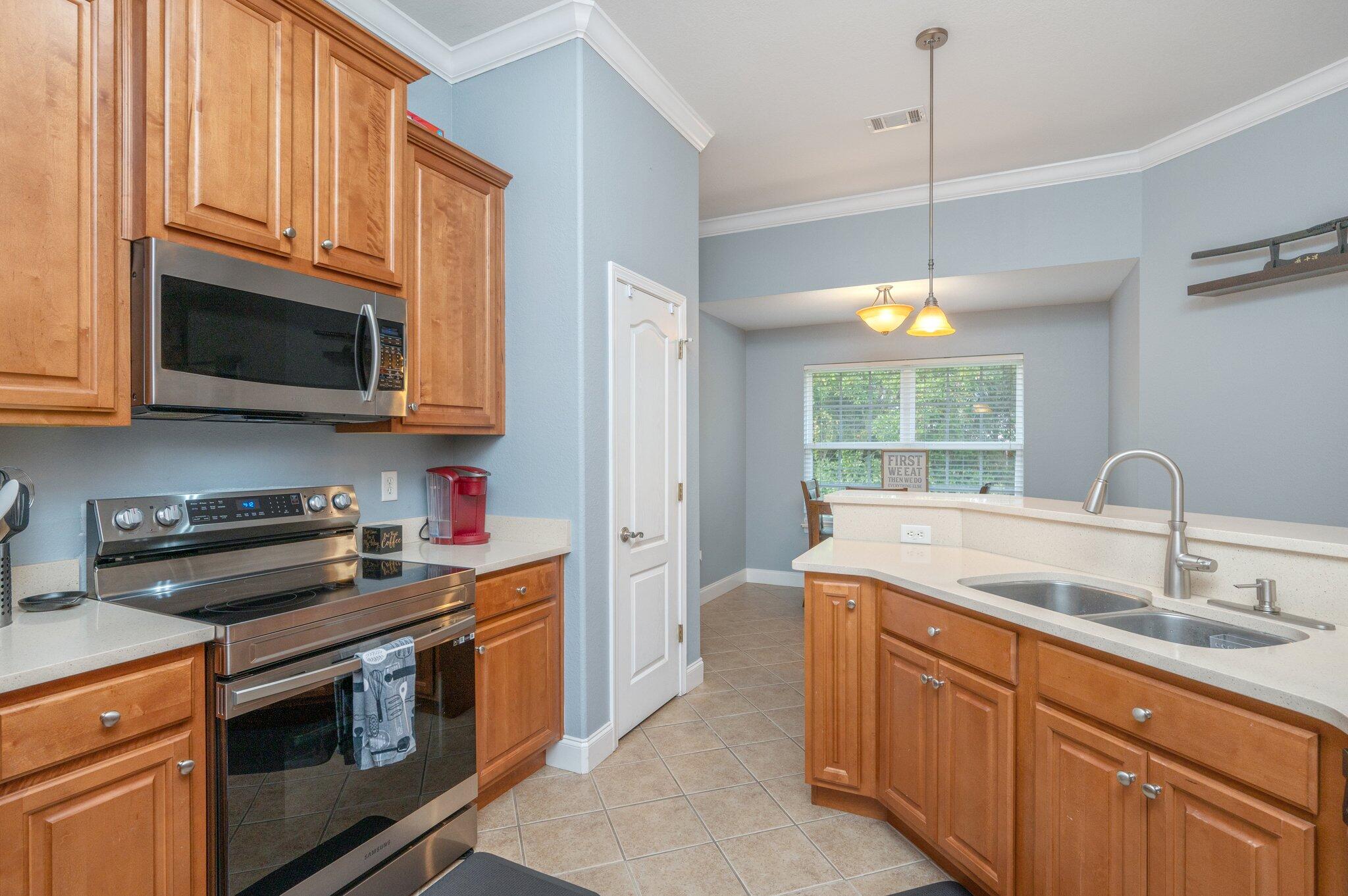 730 Riva Ridge Drive Crestview, FL 32539 - Photo 8 of 29 a kitchen with stainless steel appliances granite countertop a sink a stove a microwave and wooden cabinets