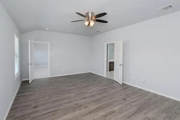 wooden floor in an empty room with a ceiling fan