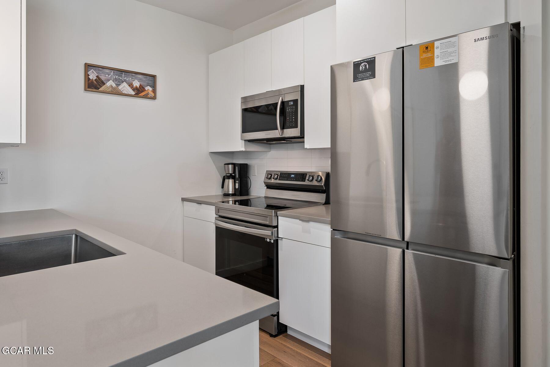 421 West Meadow Mile, Unit 3 Fraser, CO 80442 - Photo 9 of 29 a kitchen with stainless steel appliances a refrigerator sink and stove